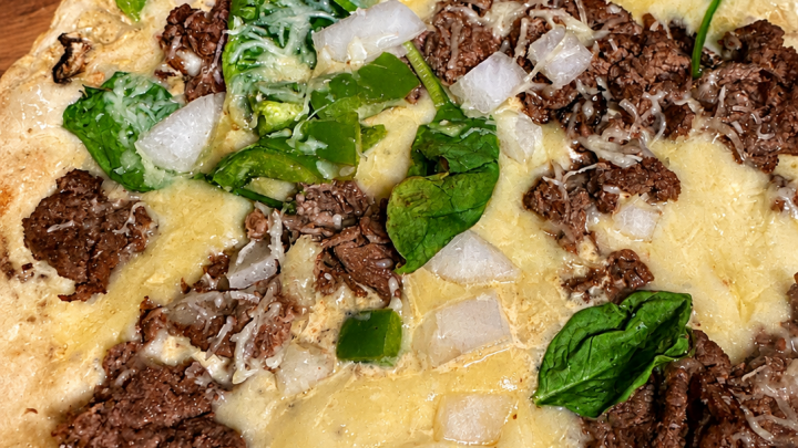 High-protein cheesesteak Cauliflower pizza recipe with shaved beef and melted cheese
