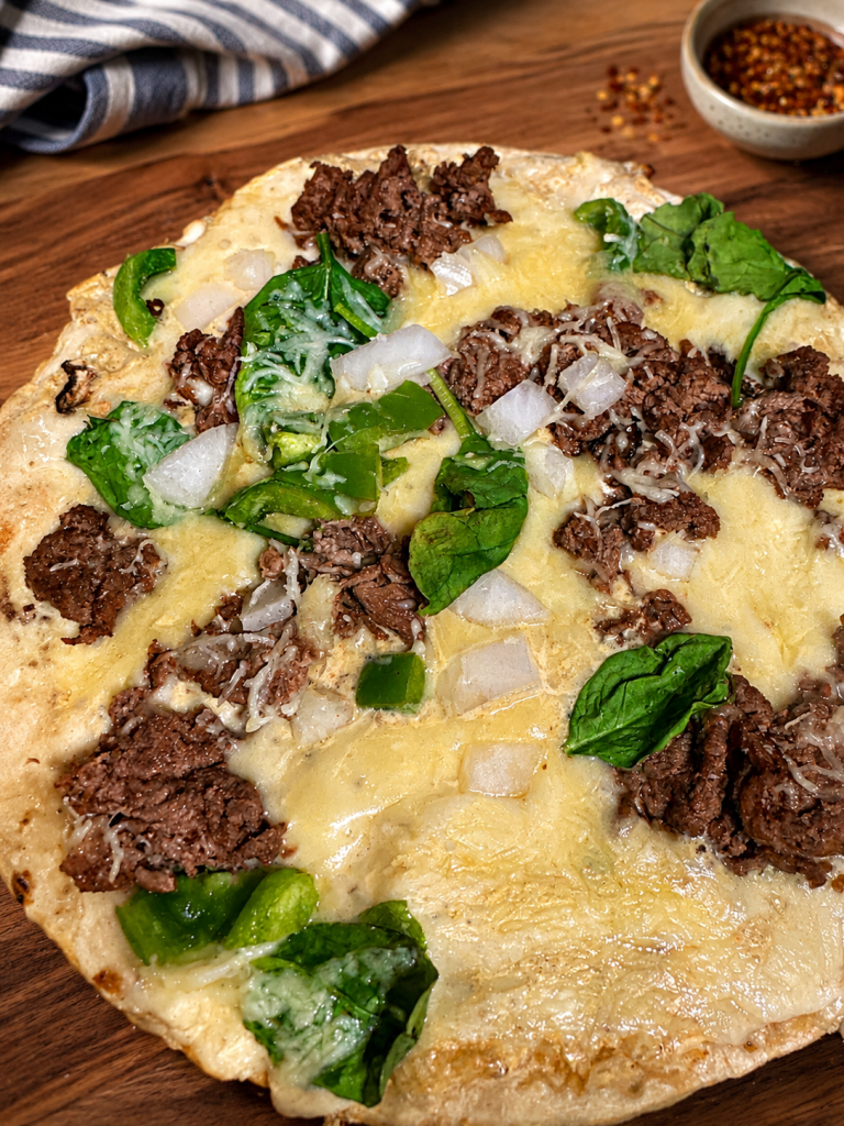 High-protein Philly cheesesteak Cauliflower pizza recipe with shaved beef and melted cheese